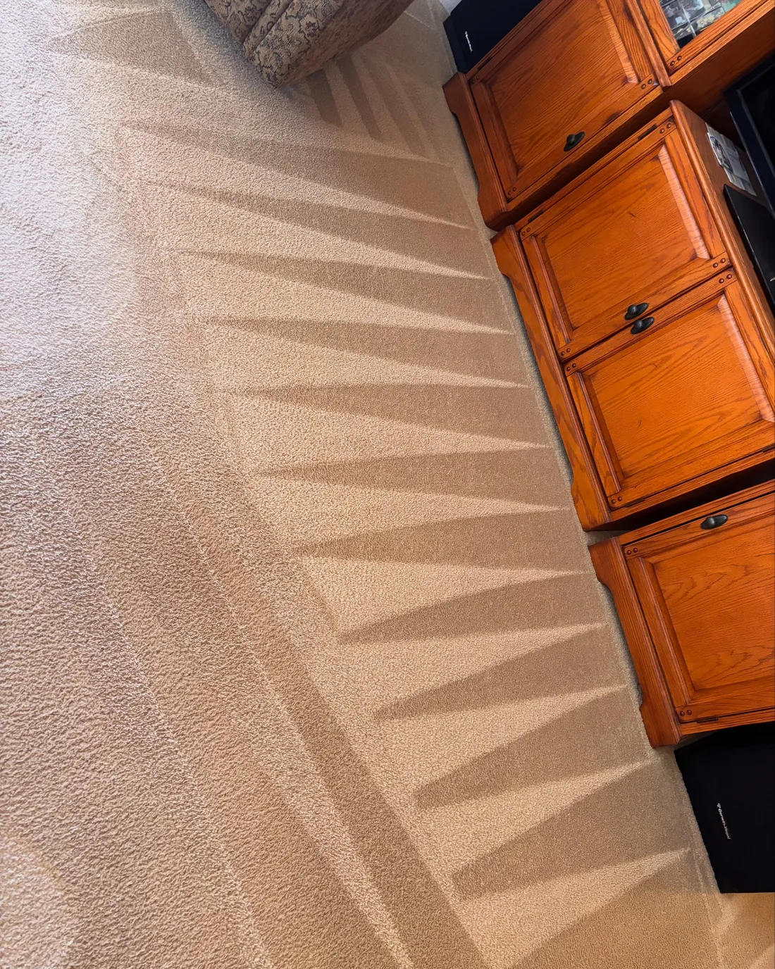 Fan-pattern finishing lines in beige carpet beside oak cabinets, same-day carpet cleaning in the Phoenix area