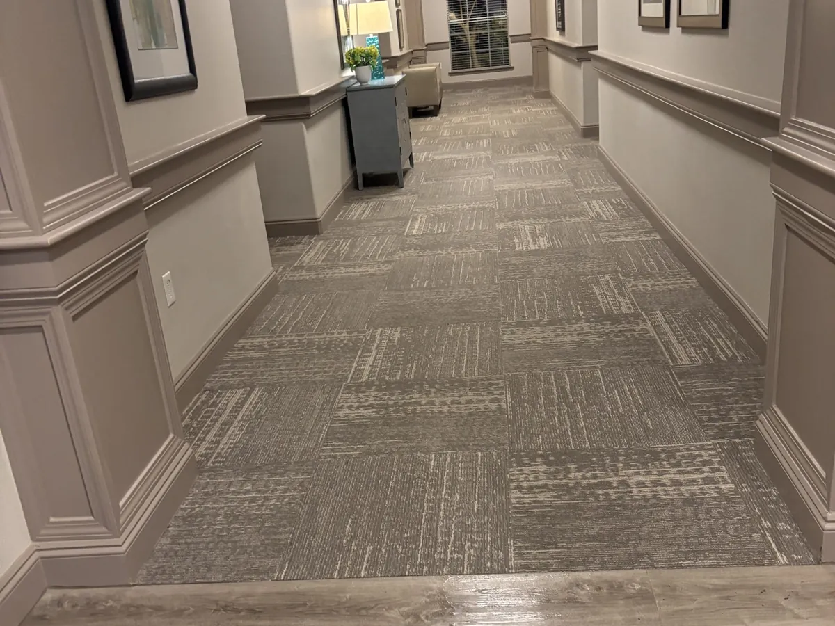 Glue-down carpet tile in a corridor after cleaning