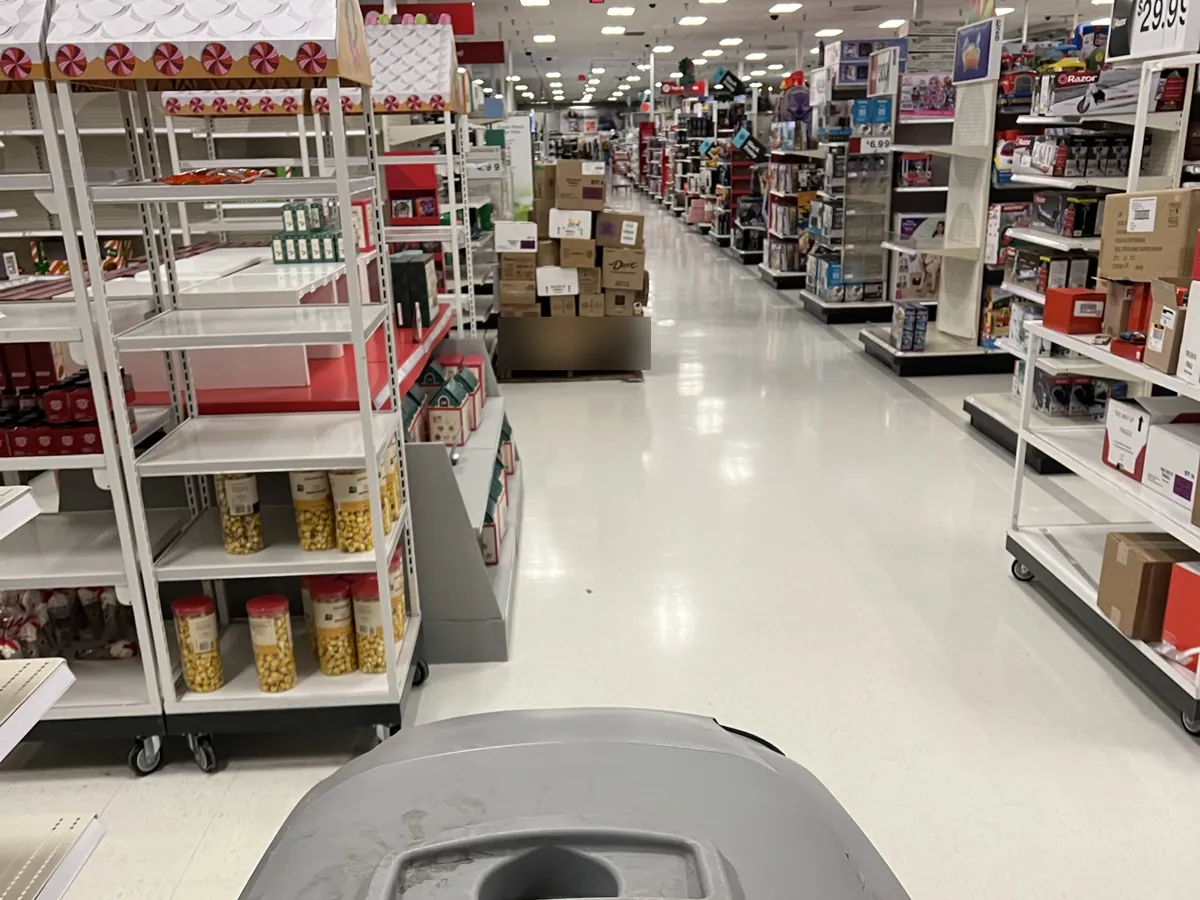 Floor scrubber running a retail aisle after close