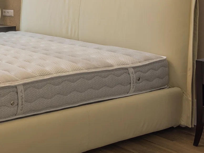 Quilted mattress on a bed frame after cleaning