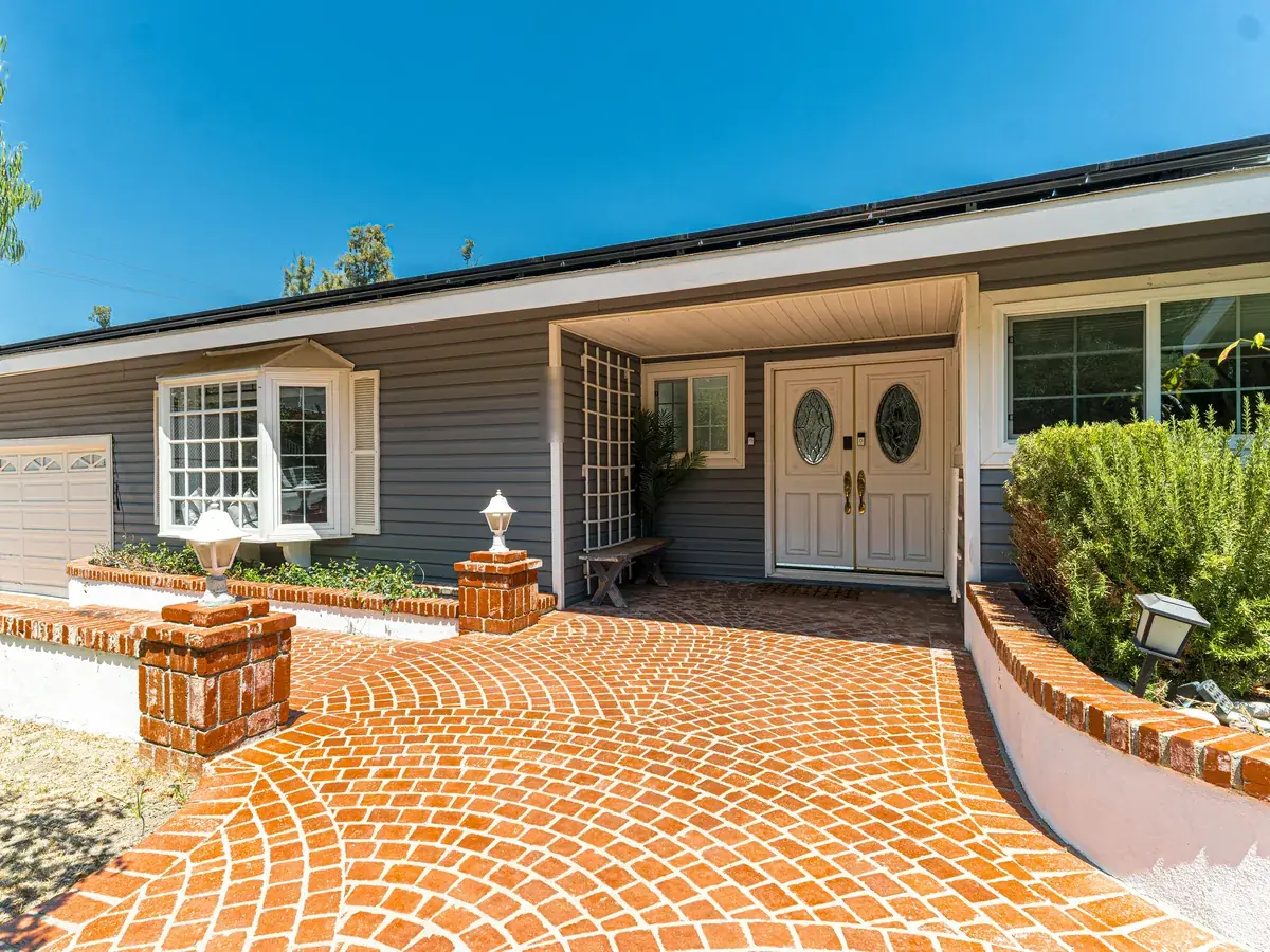 Brick paver walkway in a fan pattern leading to a front door
