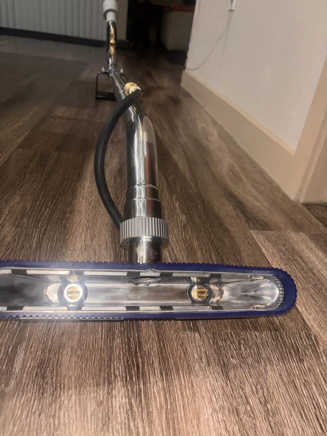 Pfaff Cleaning Co. tile and grout cleaning tool, with spray jets inside a brush-lined head that rinses and extracts in one pass