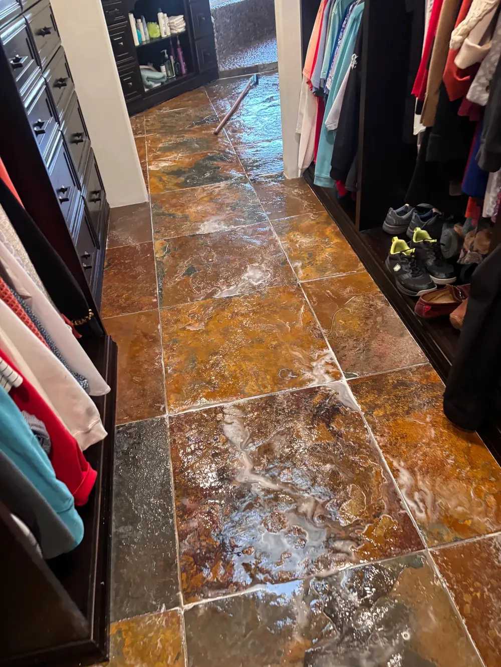 Slate floor mid-clean with solution worked across the stone