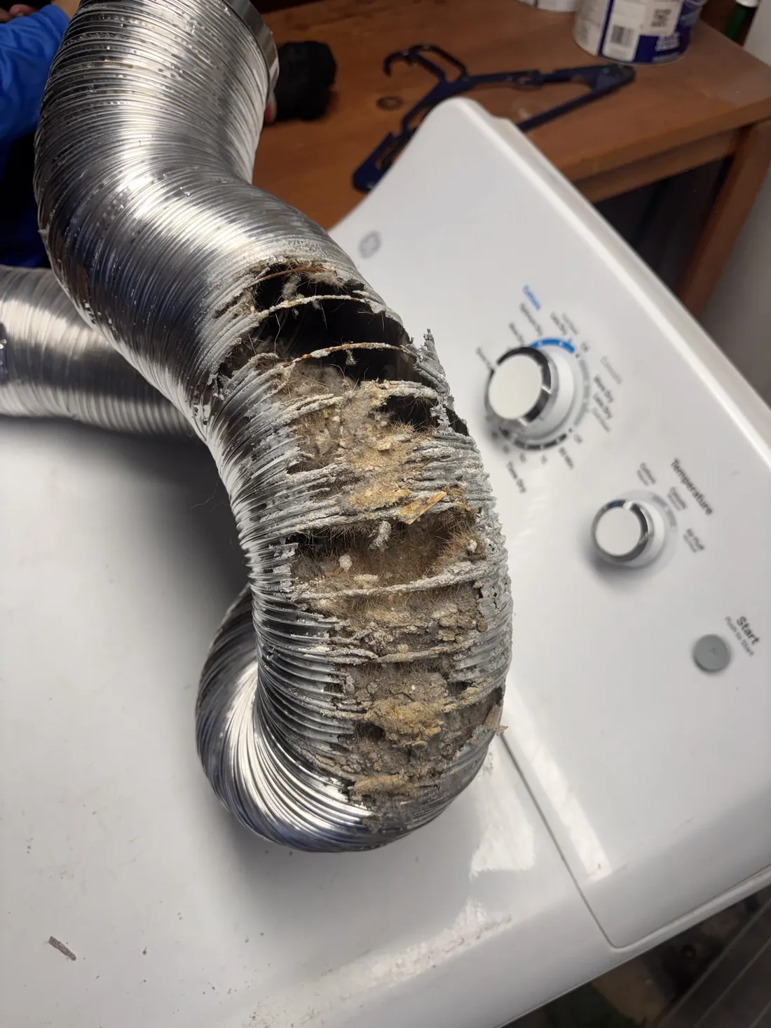 Torn foil dryer hose packed with lint, replaced on a dryer vent cleaning in Tempe AZ
