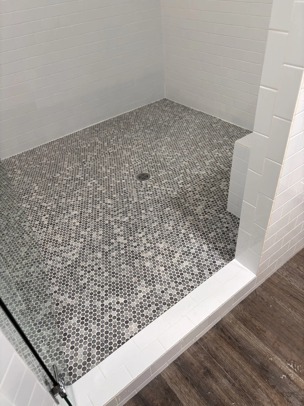 Penny round mosaic shower floor and white subway walls after cleaning
