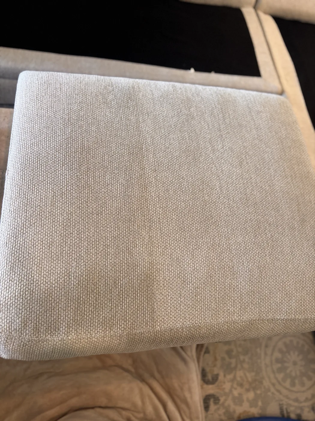 Cream linen sofa cushion after cleaning, propped to dry